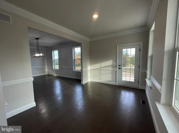 a large kitchen with stainless steel appliances kitchen island granite countertop a stove a sink a refrigerator and a dining table with wooden floor