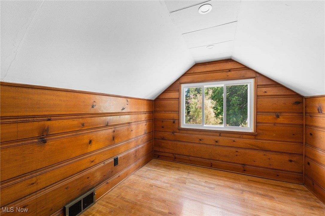 18122 Nottingham Road Cleveland, OH 44119 - Photo 20 of 29 Bedroom featuring light wood finished floors, vaulted ceiling, and wood walls
