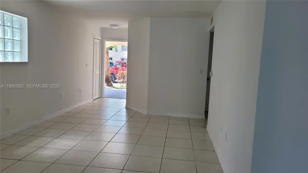 an empty room with entrance and windows