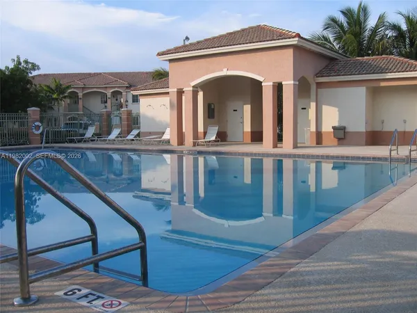 front view of a house with a yard and palm trees