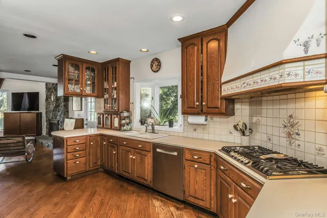 a kitchen with stainless steel appliances granite countertop wooden cabinets a sink dishwasher a stove and a refrigerator