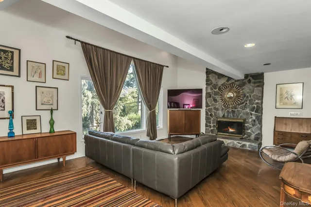 a living room with furniture a fireplace and a large window