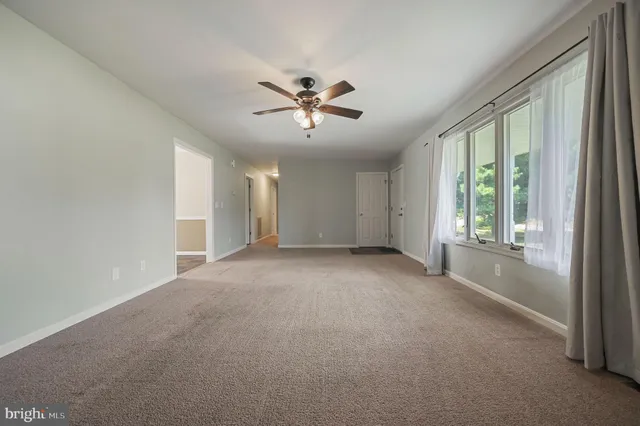 a view of a livingroom with a ceiling fan and window