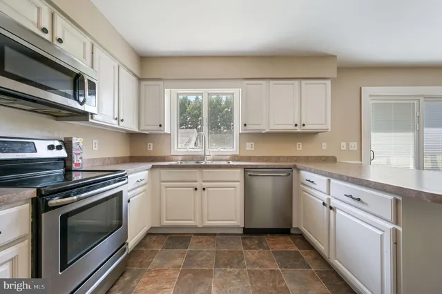 a kitchen with cabinets appliances and a window