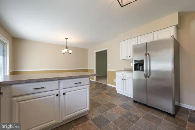 a kitchen with a refrigerator sink and cabinets