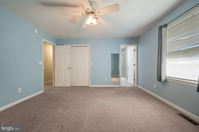 a view of a big room with windows and chandelier fan