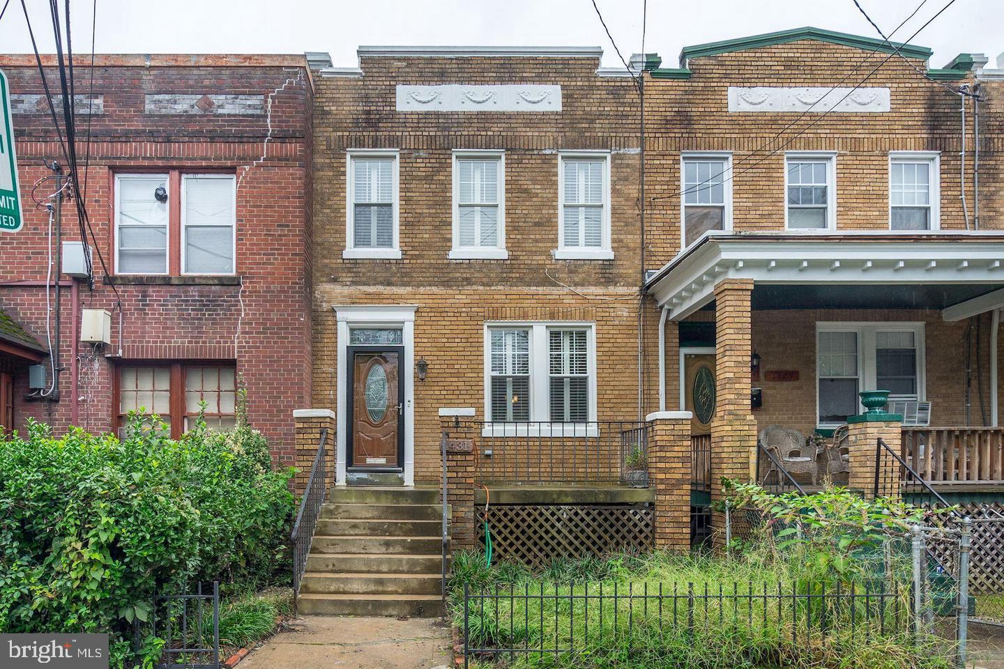 front view of a brick house with a yard