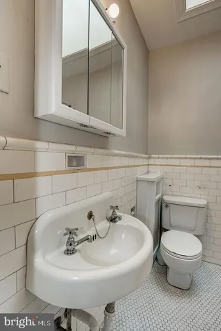 a bathroom with a sink toilet and mirror