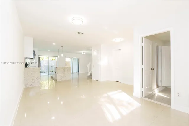 a view of a kitchen and an empty room