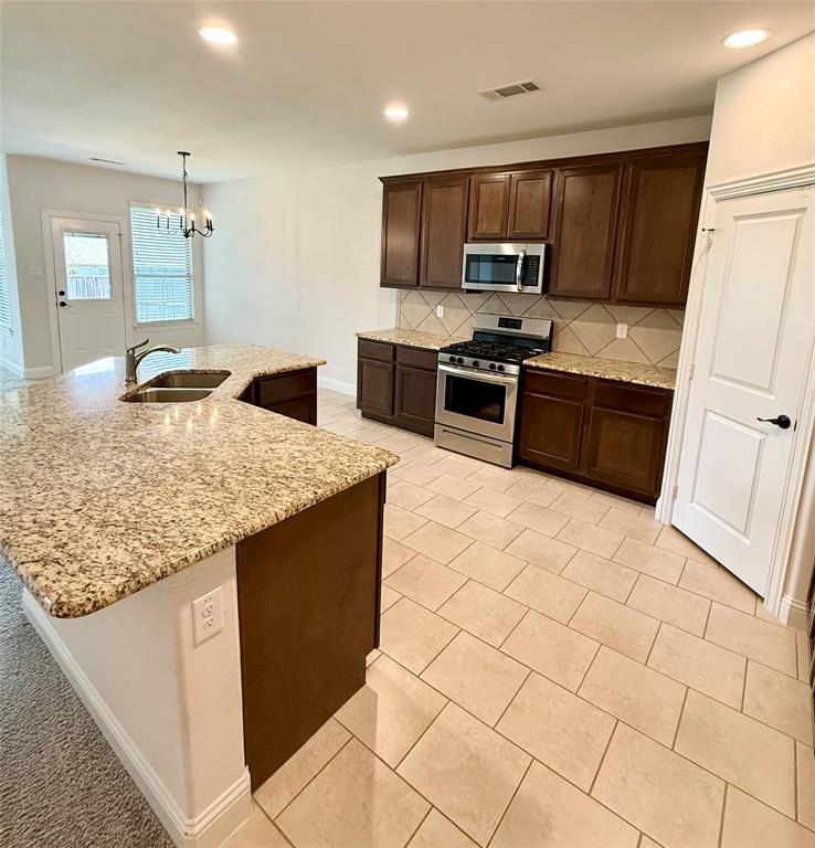 204 Flower Ridge Drive Fort Worth, TX 76108 - Photo 16 of 27 a kitchen with stainless steel appliances granite countertop a sink stove and refrigerator