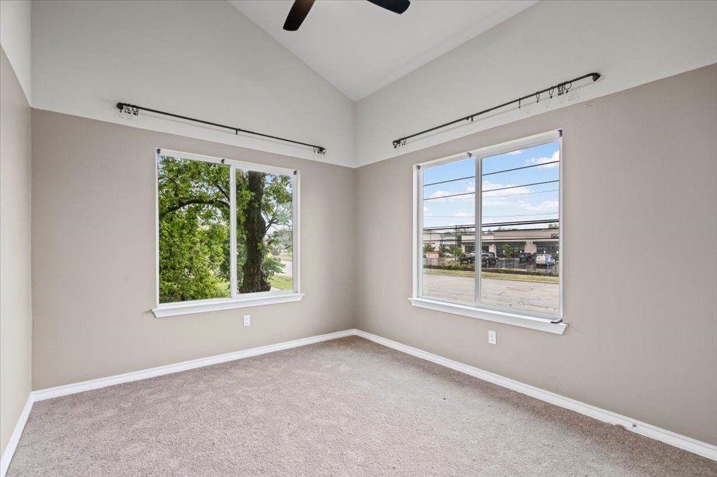 2947 Moss Street Austin, TX 78722 - Photo 14 of 20 Spacious room featuring vaulted ceilings, neutral-toned walls, and carpet flooring
