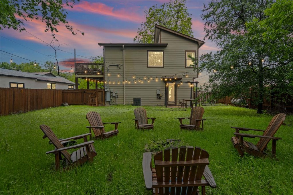 2947 Moss Street Austin, TX 78722 - Photo 20 of 20 Spacious backyard featuring a two-story home with a ground-level patio, an upper-level deck, and string lighting