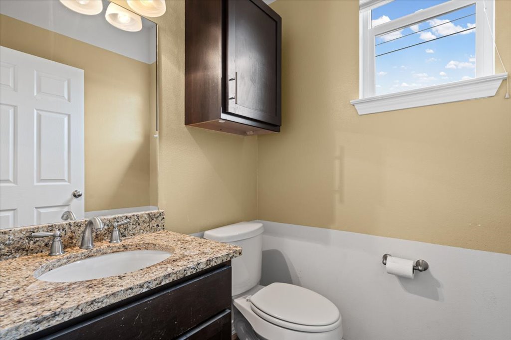 2947 Moss Street Austin, TX 78722 - Photo 9 of 20 Bathroom featuring a vanity with a light-colored stone countertop, an undermount sink, and a dark wood-finish cabinet