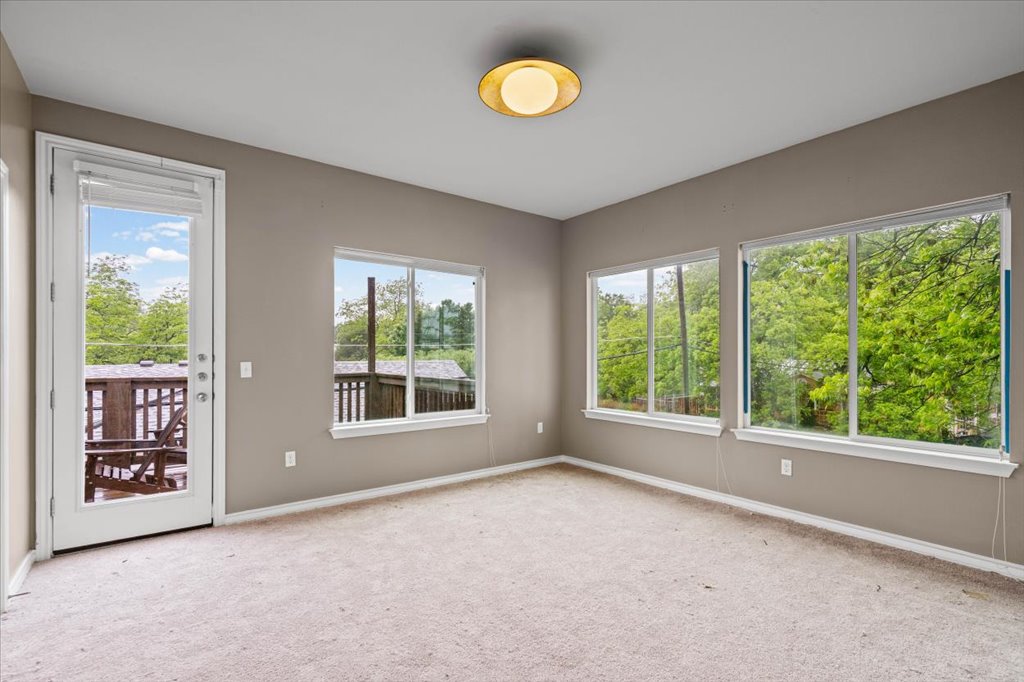 2947 Moss Street Austin, TX 78722 - Photo 10 of 20 Carpeted room with a private balcony, multiple large windows, and a flush mount ceiling light fixture