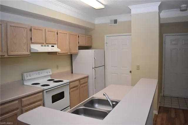 a kitchen with white cabinets and white appliances