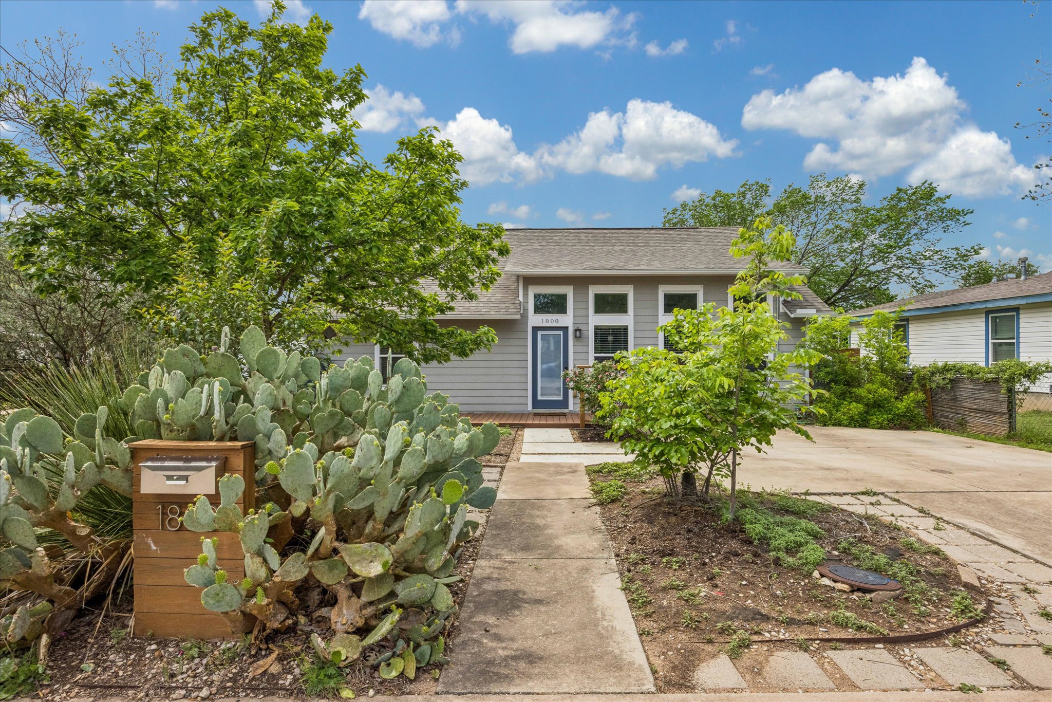 1800 Deloney Street Austin, TX 78721 - Photo 1 of 25 a pathway of a house with potted plants and a bench