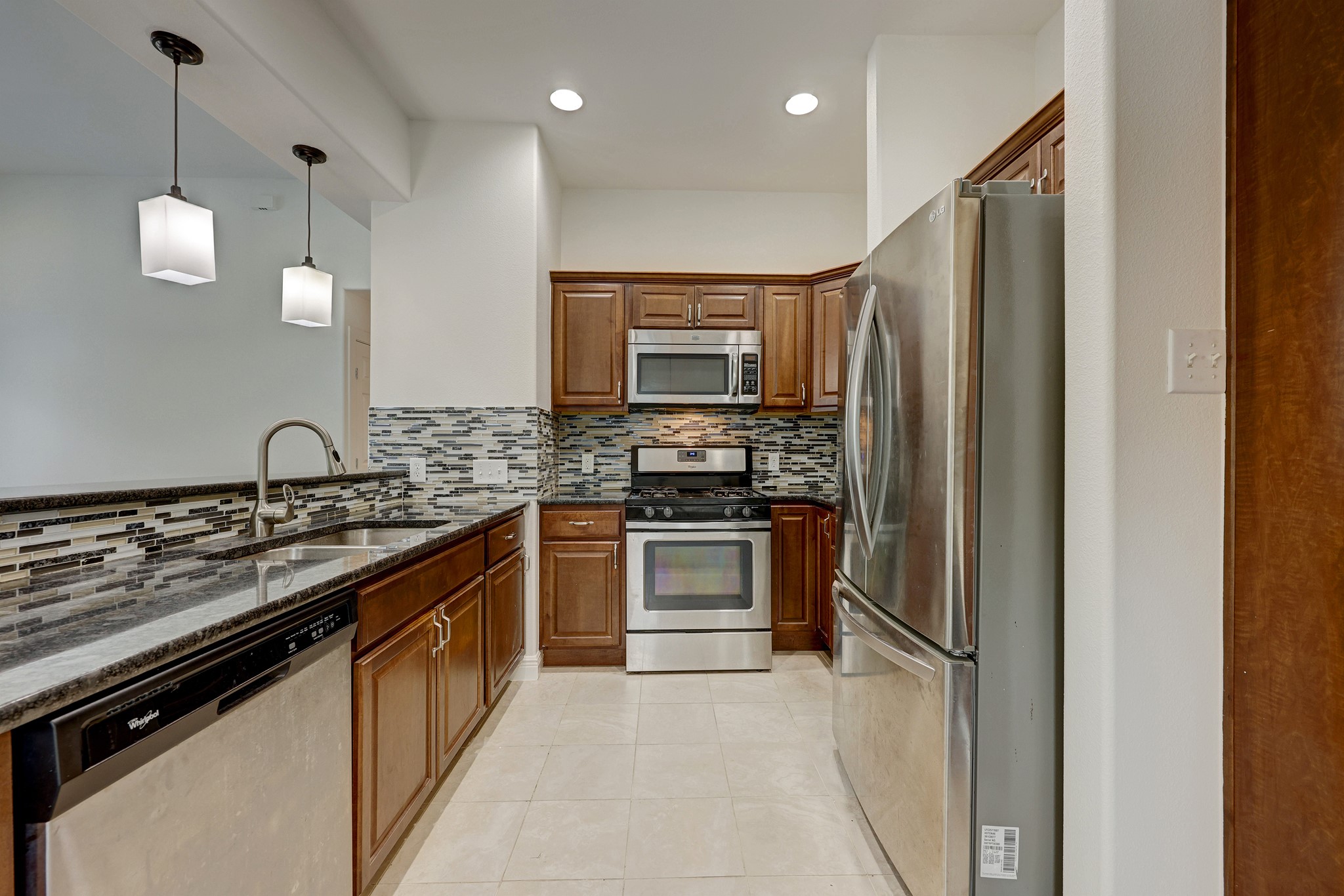 1800 Deloney Street Austin, TX 78721 - Photo 11 of 25 a kitchen with stainless steel appliances granite countertop a stove and a refrigerator