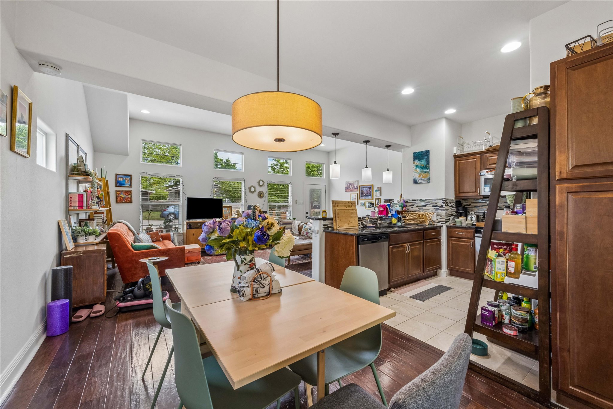 1800 Deloney Street Austin, TX 78721 - Photo 8 of 25 a kitchen with stainless steel appliances granite countertop a refrigerator a microwave oven a dining table and chairs with wooden floor