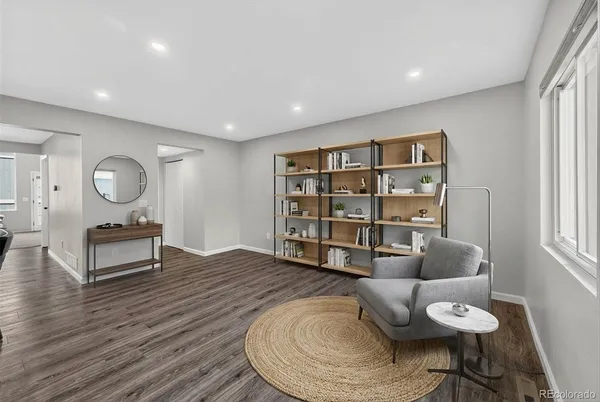 a living room with furniture and a wooden floor