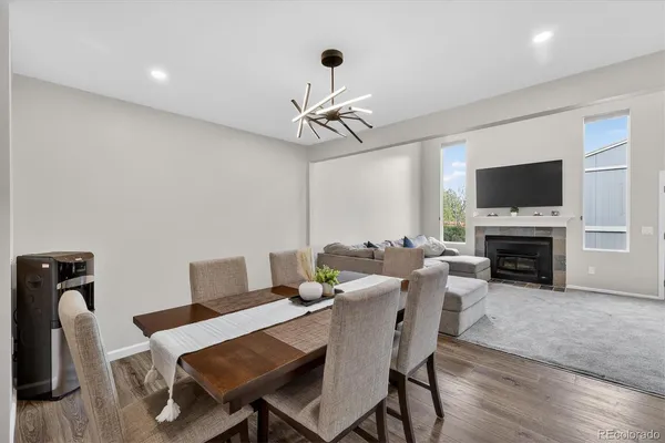 a view of a dining room with furniture wooden floor and a fireplace