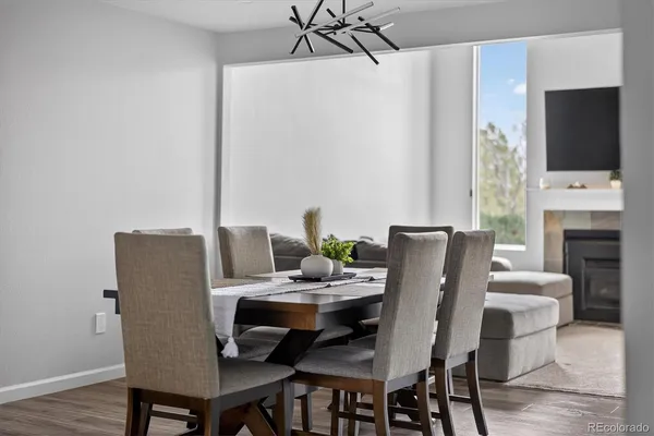 a dining room with furniture a chandelier and wooden floor