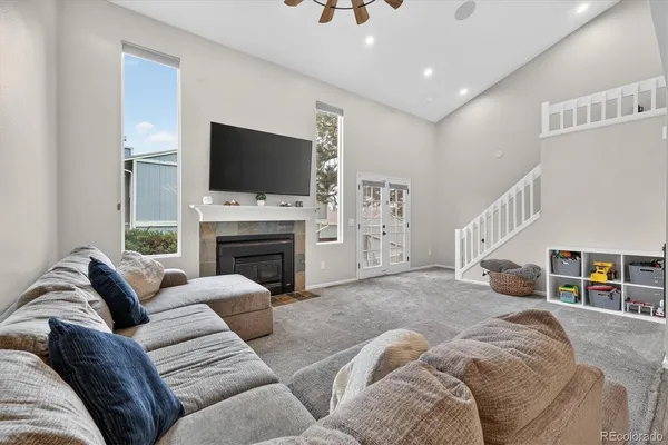 a living room with furniture a flat screen tv and a fireplace