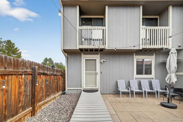 a view of a house with wooden deck and furniture