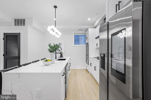 a room with stainless steel appliances a chandelier