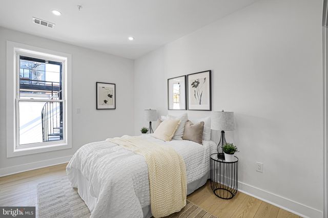 a bed room with a bed and painting on the wall