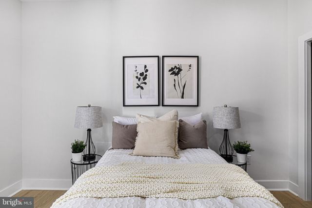 a bedroom with a bed and painting on the wall