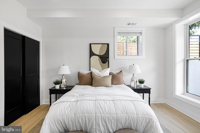 a bedroom with a bed and a painting on the wall