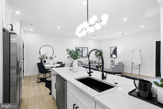 a kitchen with a sink a counter and a view of living room