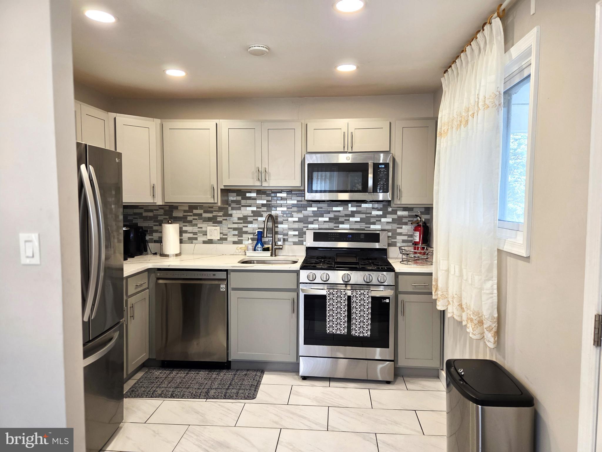 7613 Wilhelm Avenue Rosedale, MD 21237 - Photo 49 of 96 a kitchen with stainless steel appliances granite countertop a stove a refrigerator and a microwave