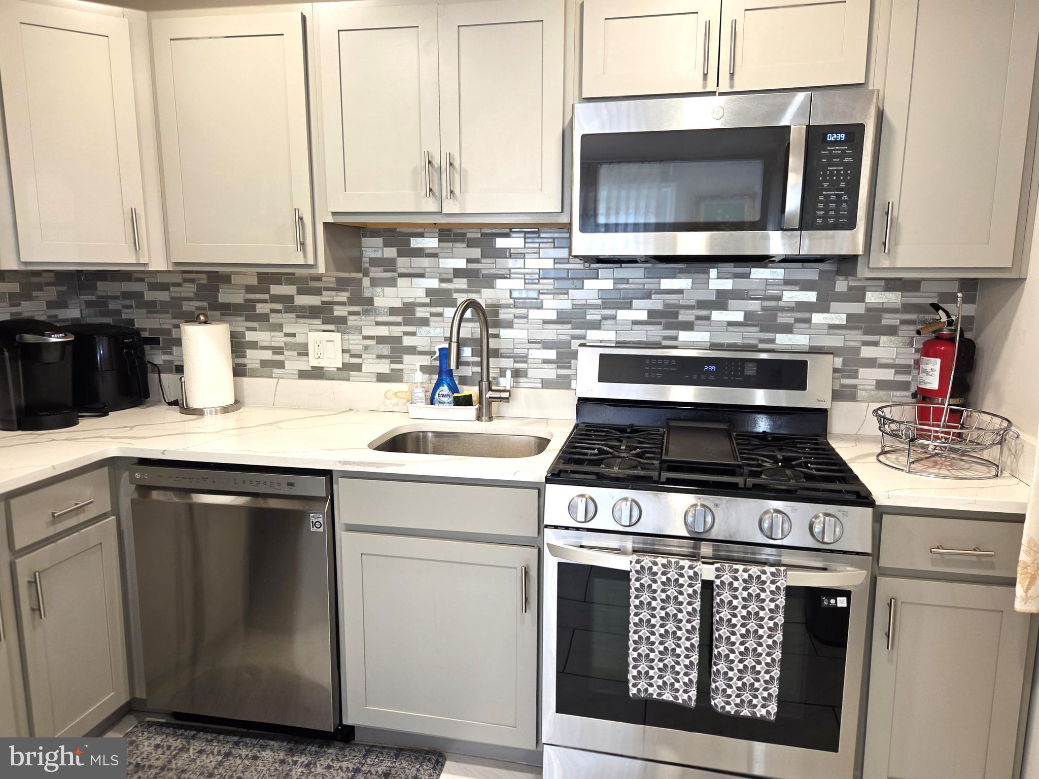 7613 Wilhelm Avenue Rosedale, MD 21237 - Photo 52 of 96 a kitchen with granite countertop a stove sink and microwave