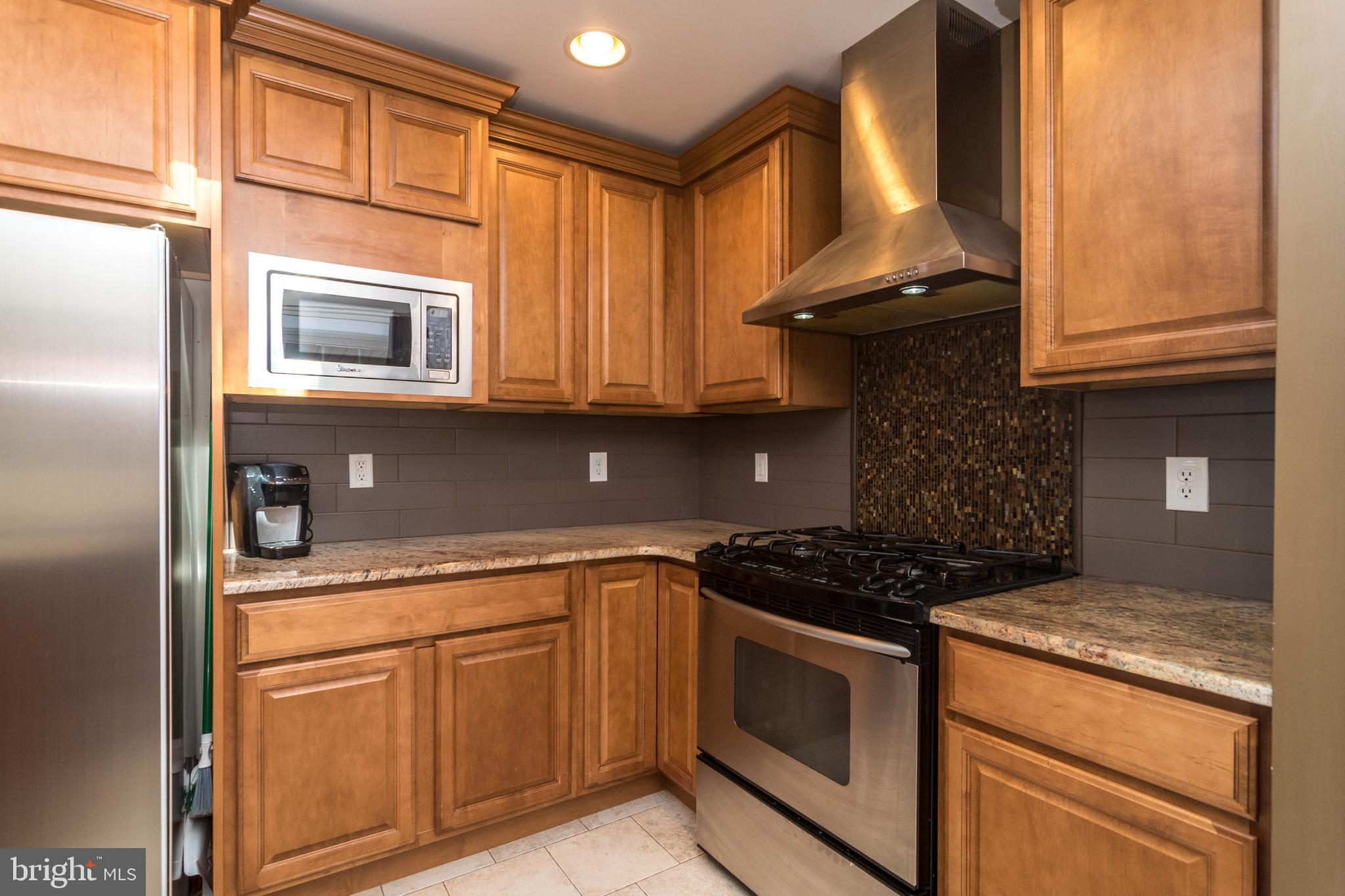 1306 Sylvan Road Perkasie, PA 18944 - Photo 13 of 47 a kitchen with stainless steel appliances granite countertop a stove and a microwave