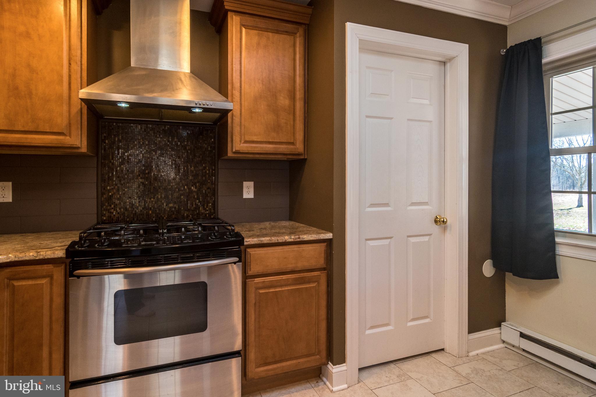 1306 Sylvan Road Perkasie, PA 18944 - Photo 18 of 47 a kitchen with granite countertop white cabinets and black appliances