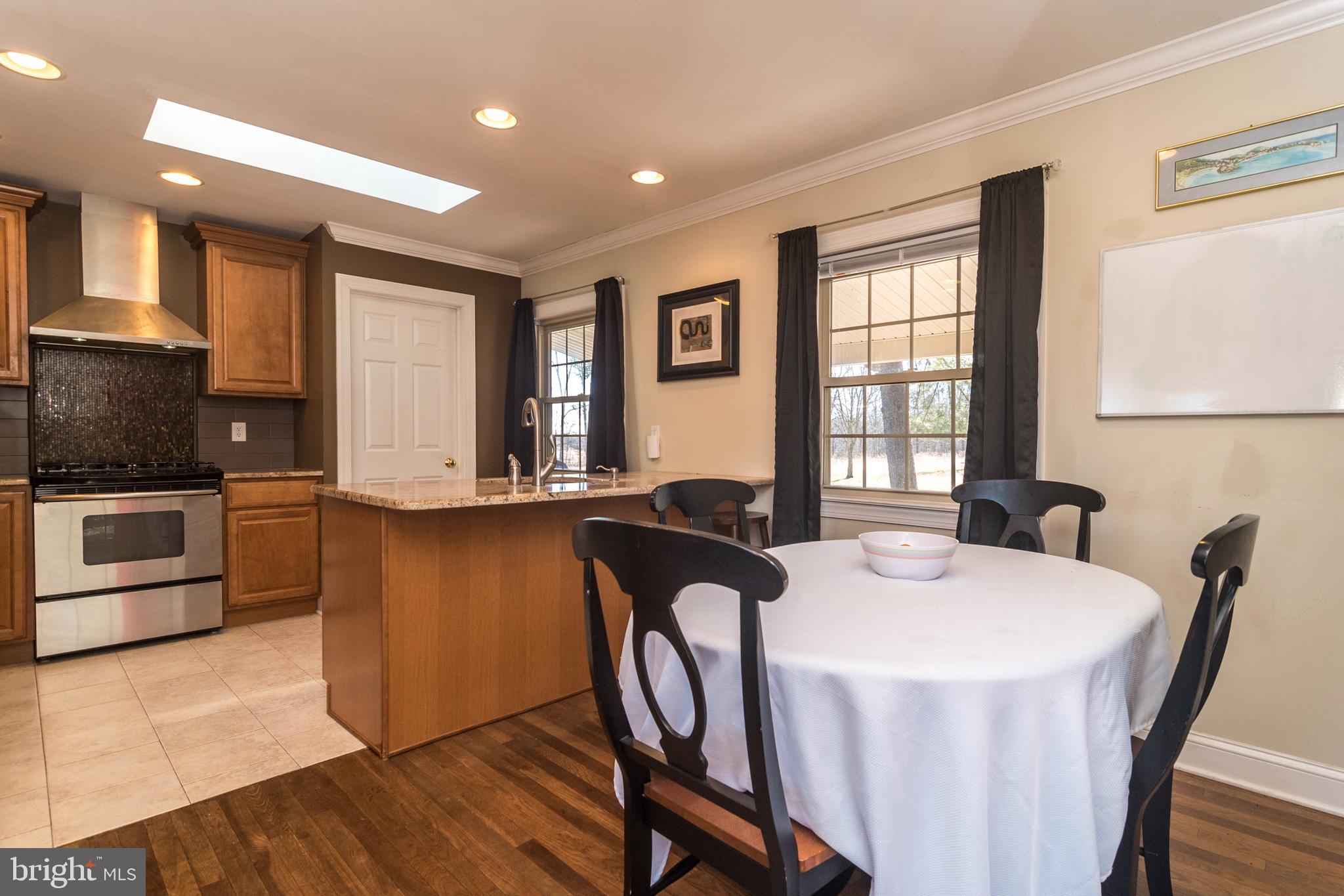 1306 Sylvan Road Perkasie, PA 18944 - Photo 19 of 47 a kitchen with granite countertop a stove a sink a dining table and chairs