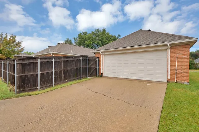a front view of a house with a garden and garage
