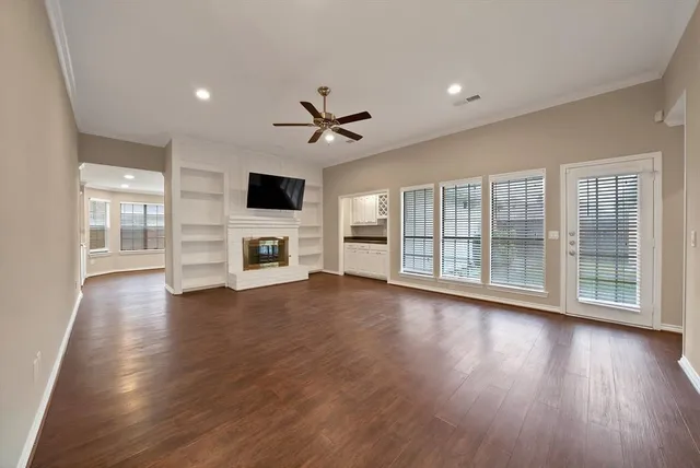 a view of a livingroom with furniture a flat screen tv and wooden floor