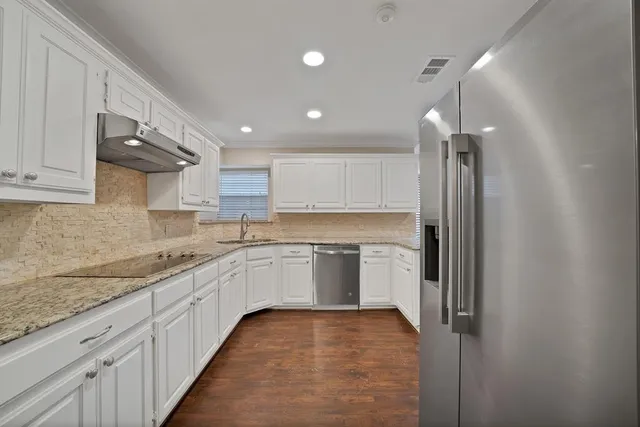a large kitchen with cabinets and stainless steel appliances