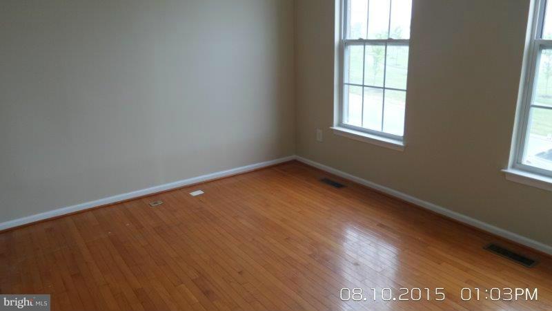 892 Lowe Road Baltimore, MD 21220 - Photo 3 of 19 an empty room with wooden floor and windows