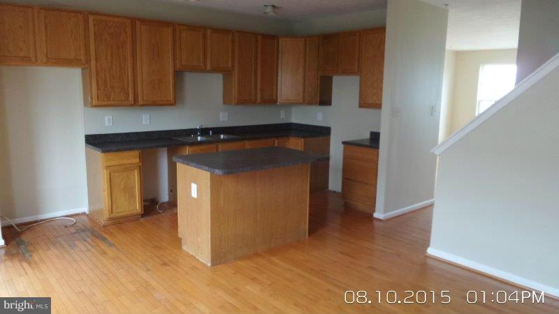 892 Lowe Road Baltimore, MD 21220 - Photo 7 of 19 a view of a kitchen with wooden floor and cabinets