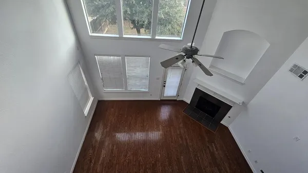 a view of a livingroom with wooden floor and a fireplace