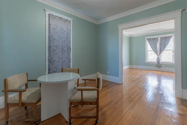 a view of a room that has a table and a chair in it