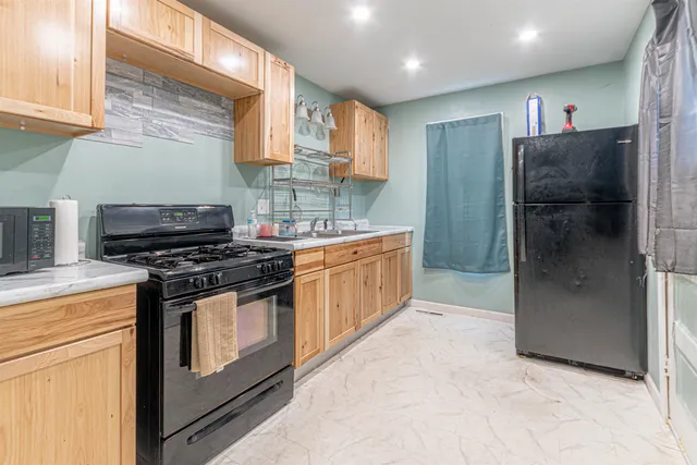 a kitchen with stainless steel appliances granite countertop a stove a refrigerator and a sink