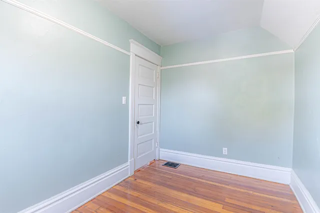 a view of room with window and wooden floor