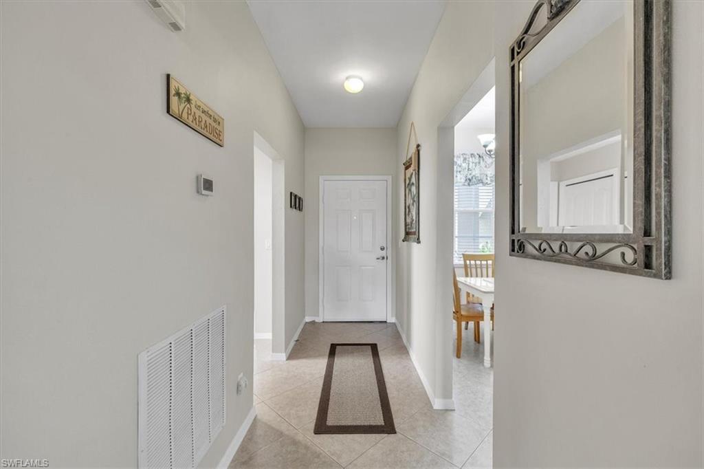 8075 Tiger Cove, Unit 1706 Naples, FL 34113 - Photo 49 of 50 Hall featuring light tile patterned floors and baseboards