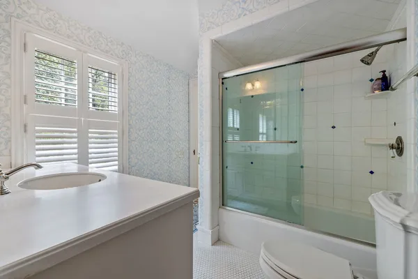 a bathroom with a sink a toilet and shower