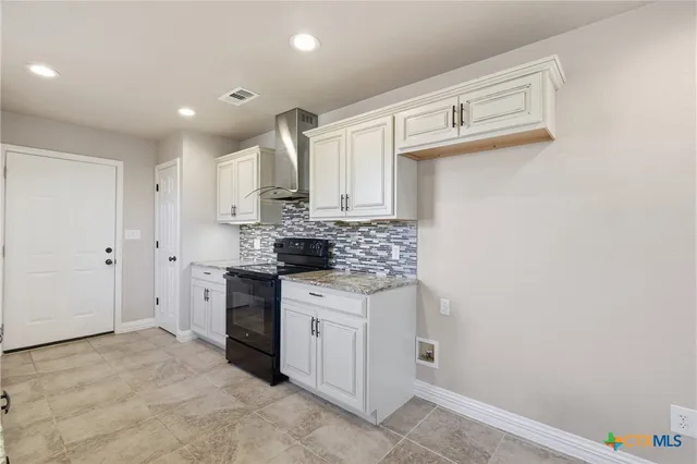 a kitchen with stainless steel appliances granite countertop white cabinets and window