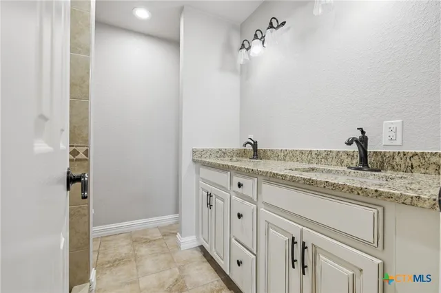 a bathroom with a granite countertop sink and a mirror